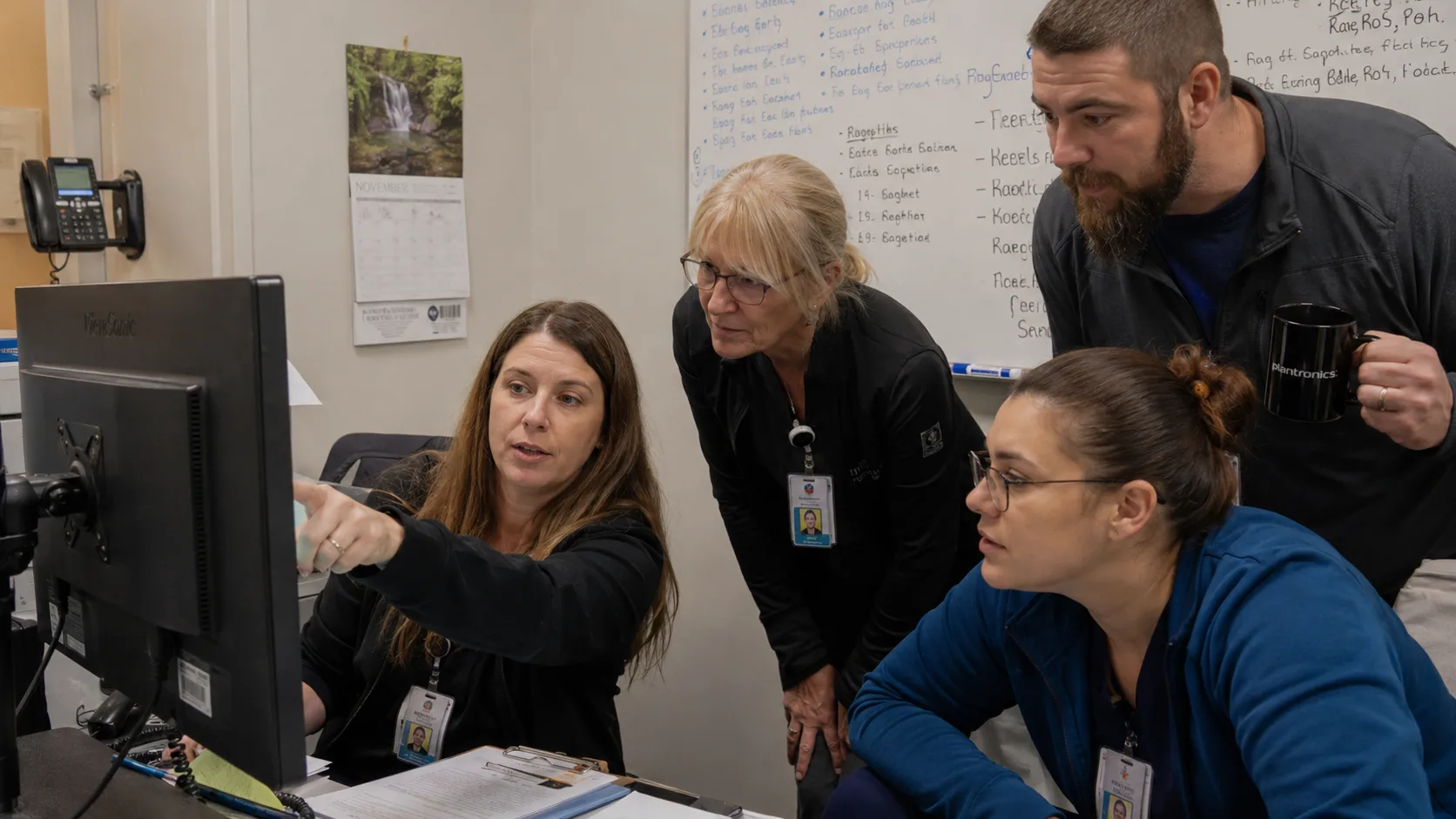 Healthcare team reviewing a training and workflow rollout together at a shared workstation